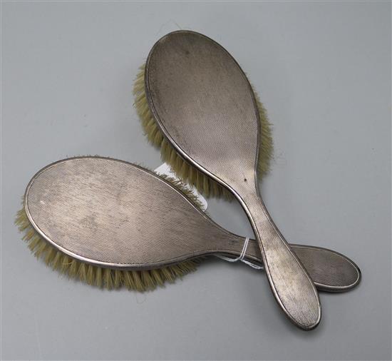 Two 1950s engine turned silver mounted hair brushes.